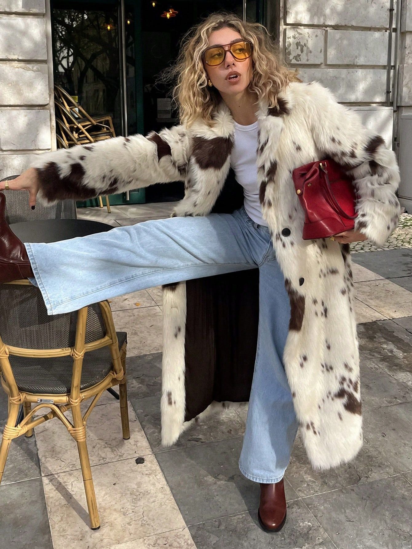 Fashionable model in a Long Faux Fur Effect Coat paired with flared jeans and stylish accessories