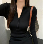 Black long sleeve short dress with a zippered neckline, perfect for casual outings