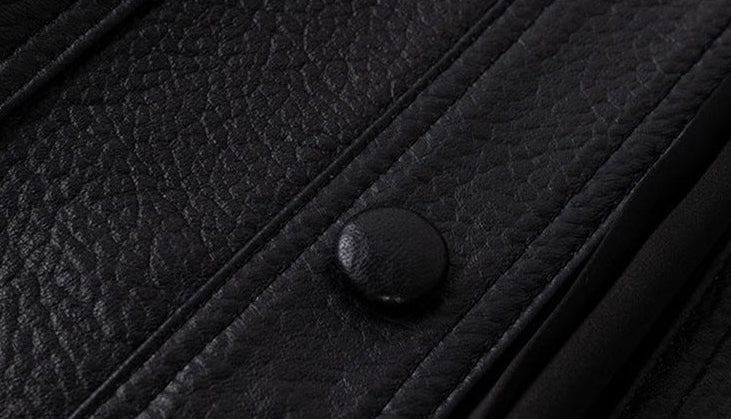 Close-up of a luxury streetwear leather jacket featuring a textured black finish and snap buttons