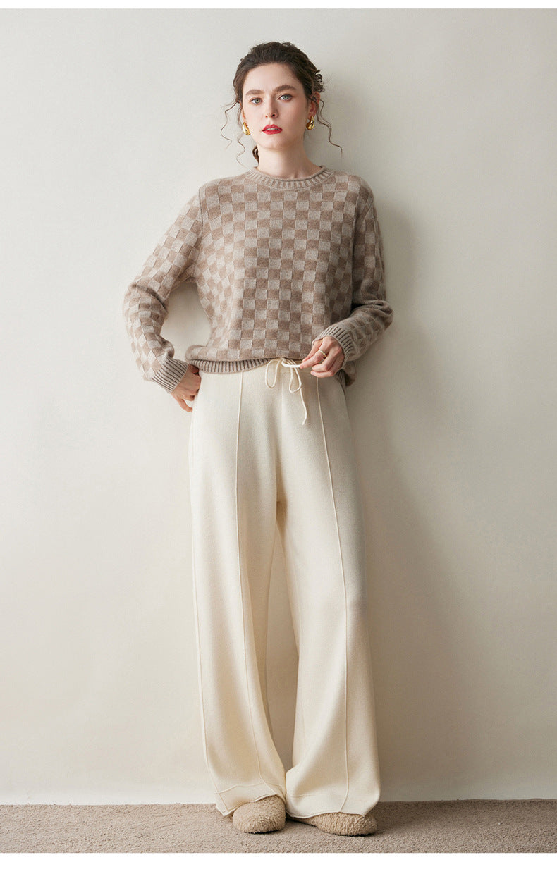 Luxury women's knit sweater in beige with a checkerboard pattern, styled with soft wide-leg pants