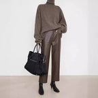 Stylish model wearing Merard Luxe Sheepskin Pants paired with a cozy sweater and a chic handbag