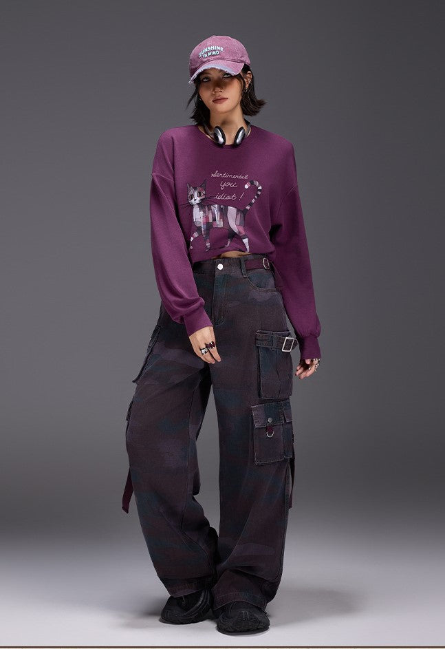 Model wearing Midnight Paws Street Top in purple with graphic design, paired with cargo pants and cap