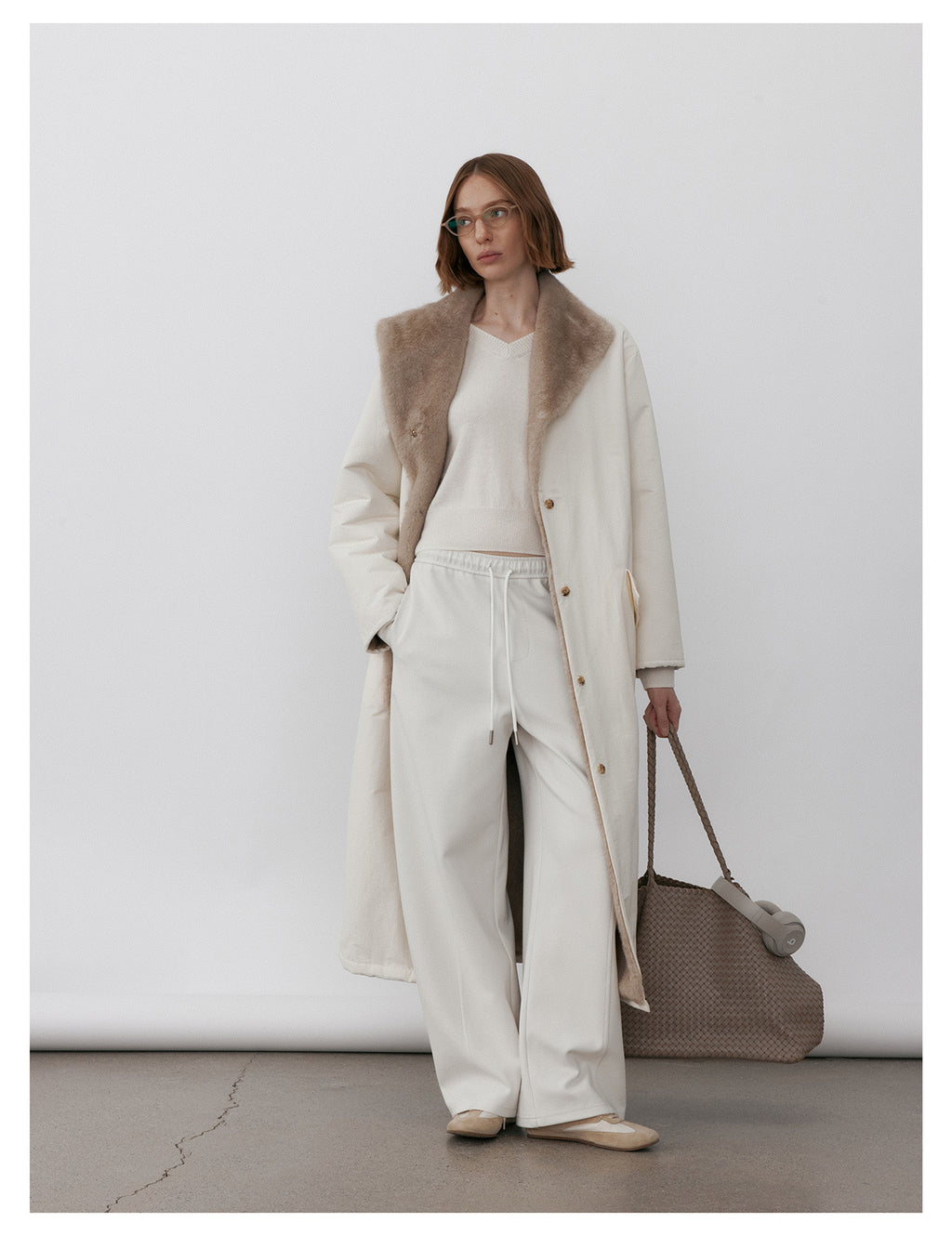 Model wearing Milk Tea Reversible Luxe Fur Trench over a cozy outfit for a stylish look