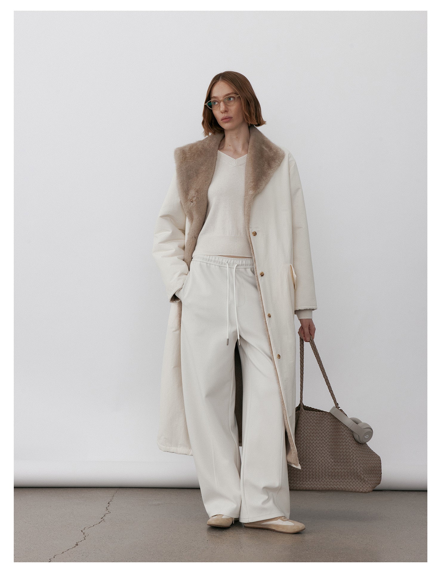 Model wearing Milk Tea Reversible Luxe Fur Trench over a cozy outfit for a stylish look