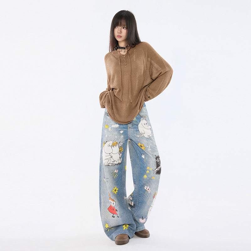 Model tanara in pulover maro oversized si Blugi Moomins Cartoon evazati din denim cu imprimeuri colorate