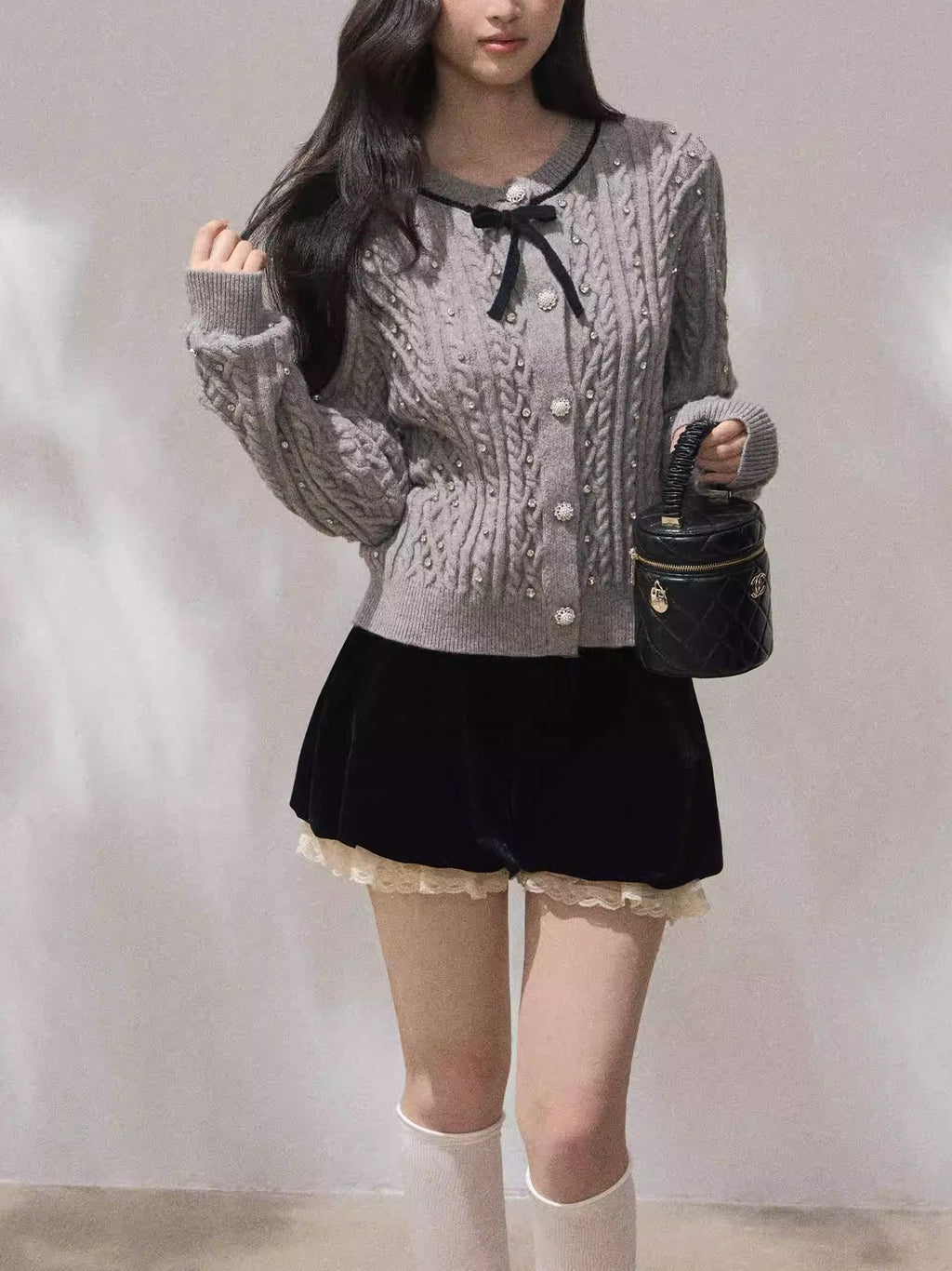 Model wearing a cozy grey Moonlight Ribbon Cardigan with button details and a stylish black skirt