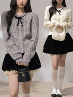 Moonlight Ribbon Cardigan in grey and cream featuring a cable knit design and bow detail