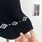 Detail of Nordic Echo Knit Set showing a stylish black sweater with geometric white patterns