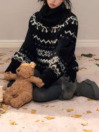 Cozy Nordic Echo Knit Set featuring a black sweater with winter designs and a model holding a teddy bear