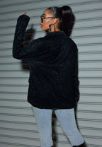 Back view of a woman wearing an oversized sequin cardigan blazer with a stylish design