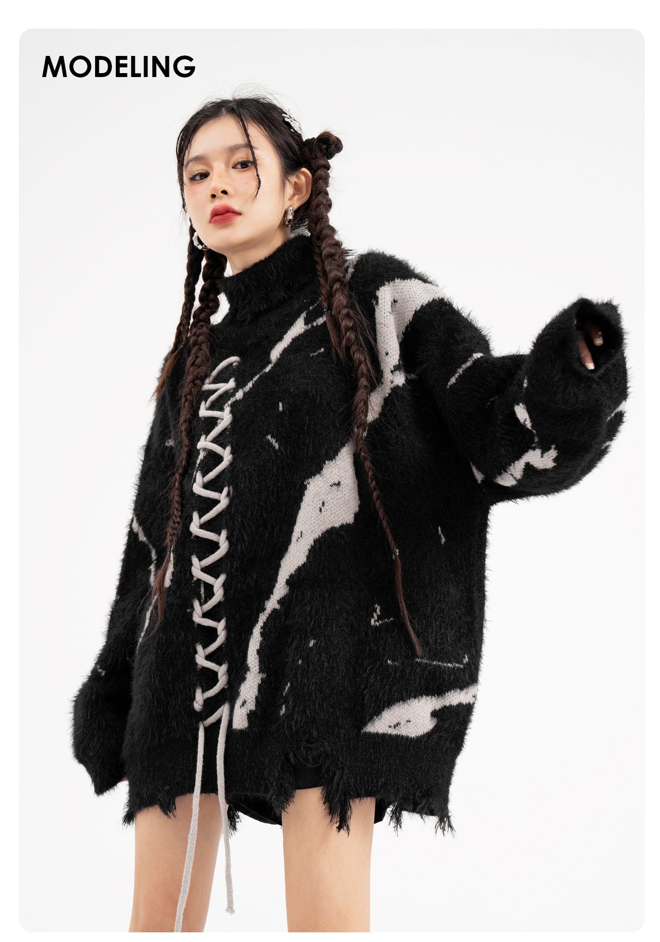Model wearing an oversized sweater with dark street design and distressed details for a trendy look