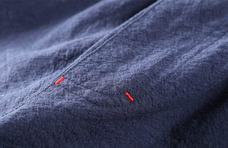Detaliu cusături roșii pe pantaloni de toamnă din in de culoare albastru închis