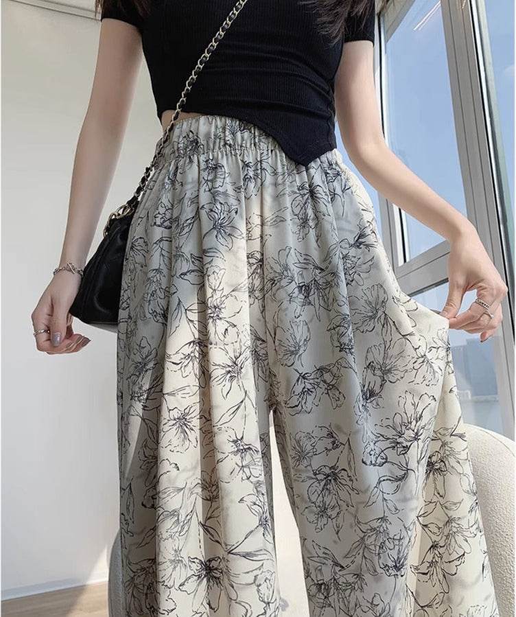 Pantaloni largi albi cu imprimeu floral negru, talie înaltă elastică, purtați cu top negru AM Vision RO