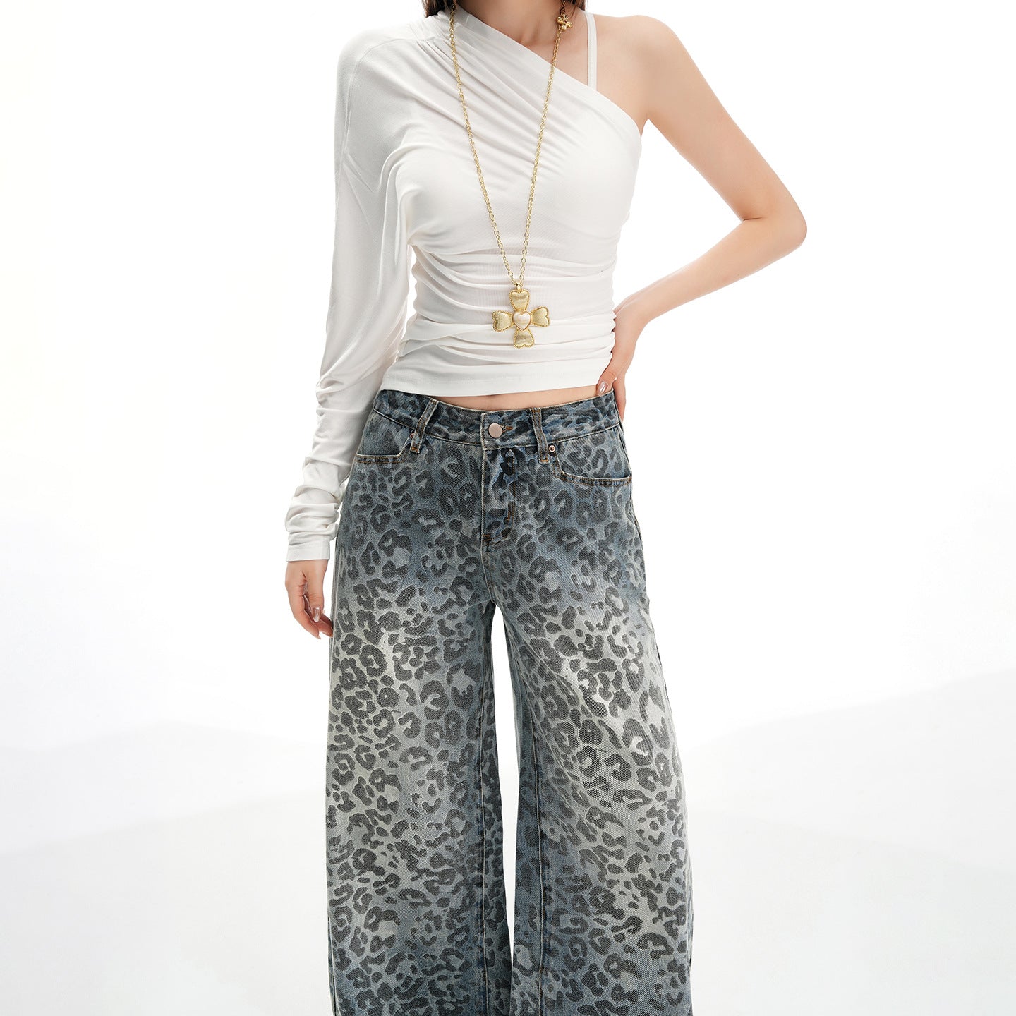 Femeie îmbrăcată în pantaloni largi din denim cu imprimeu leopard și top alb elegant