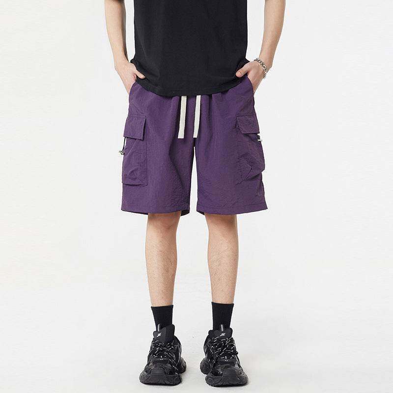 Pantaloni scurți casual cu buzunare multiple de culoare mov purtați de bărbat cu tricou negru