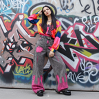 Model wearing Pink Brushstroke Gray Straight Leg Jeans with a colorful top against a graffiti background