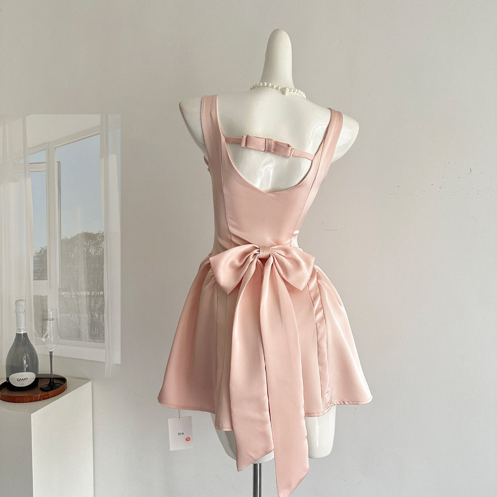 Back view of a stylish Pink Lotus Bow Princess Dress featuring a large bow and adjustable straps