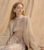 Model wearing a Provence Bloom Midi Dress with soft floral patterns and a cozy cardigan