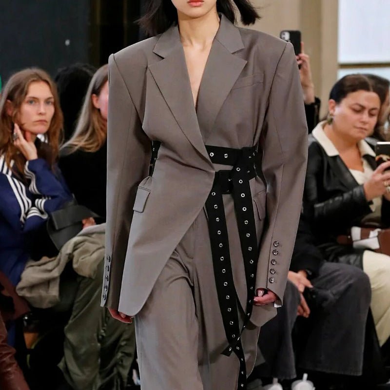 Fashion model wearing a gray Retro Blazer with Belt on the runway at a stylish event