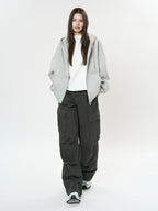 Model wearing Retro Cargo Pocket Wide Leg Denim Pants in dark color with a casual gray hoodie