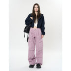 Model wearing Retro Cargo Pocket Wide Leg Denim Pants in pink with a black hoodie and sneakers