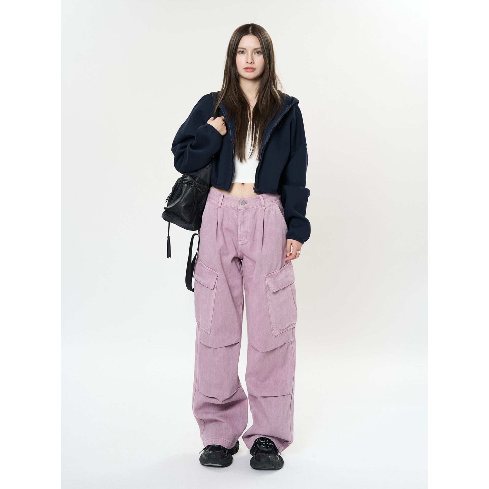 Model wearing Retro Cargo Pocket Wide Leg Denim Pants in pink with a black hoodie and sneakers