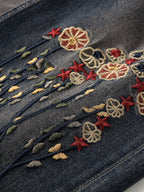 Close-up of RetroBloom Embroidered Jeans showcasing colorful floral designs on dark denim