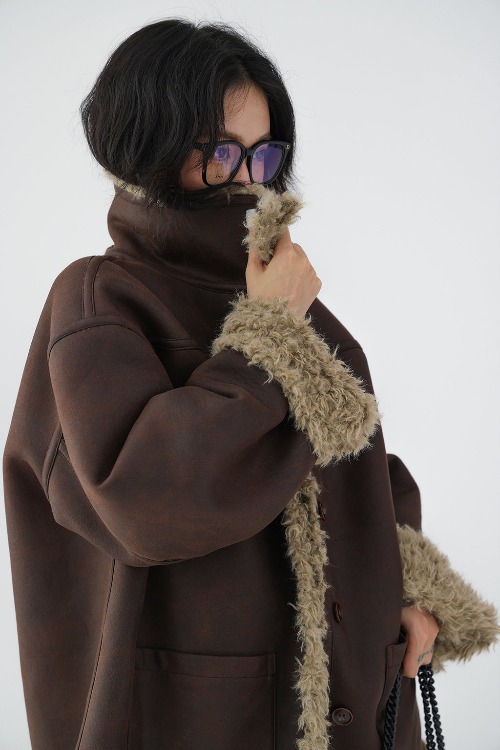 Model wearing a Reversible Winter Suede Jacket in brown with plush fur trim for added warmth and style