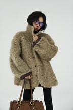 Stylish model wearing a fluffy Reversible Winter Suede Jacket paired with a brown handbag