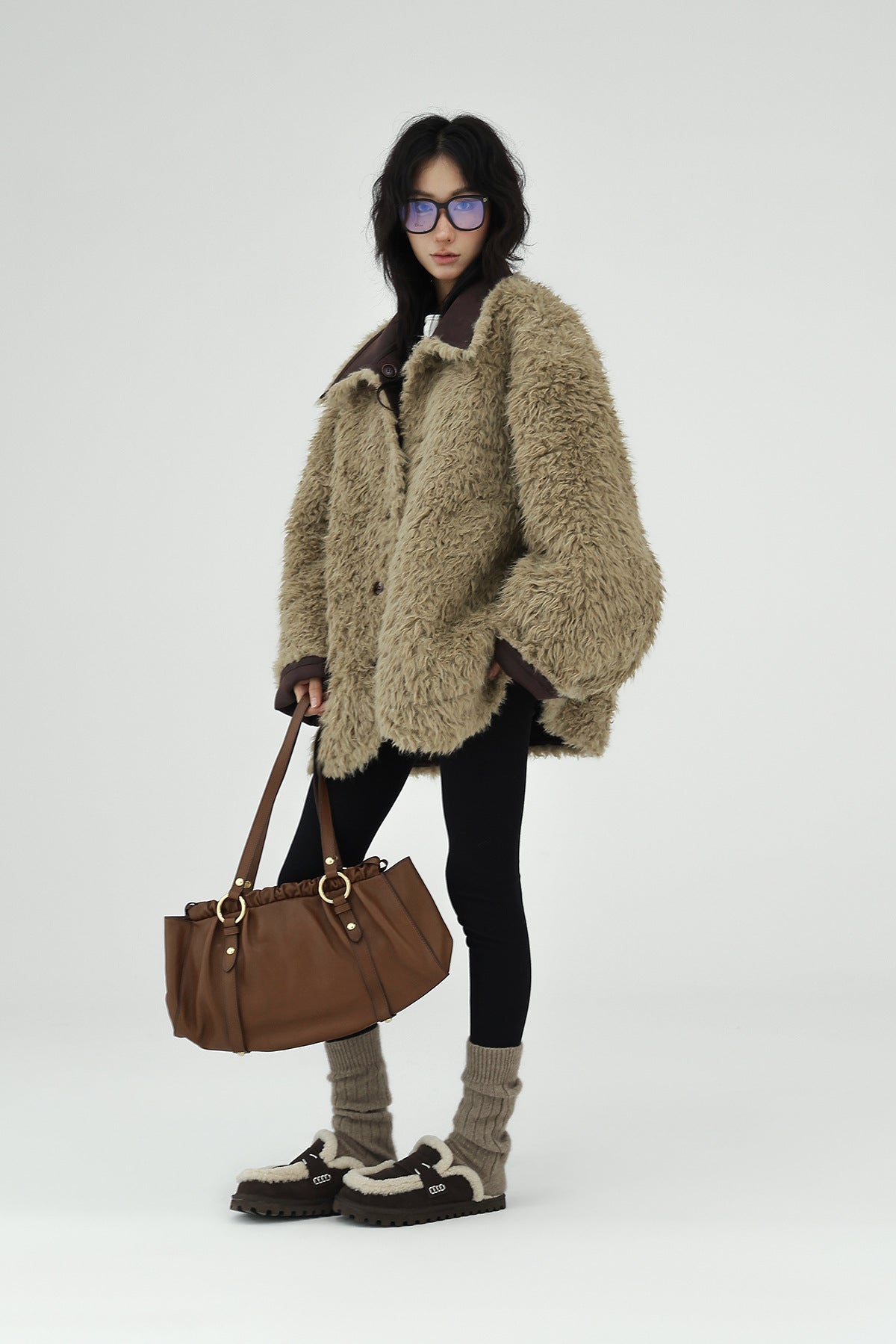 Trendy model wearing a Reversible Winter Suede Jacket paired with a stylish handbag