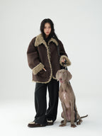 Model wearing a Reversible Winter Suede Jacket with faux fur lining, standing beside a dog