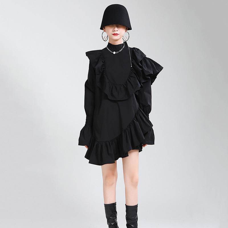 Femeie purtând o rochie asimetrică cu volane negre și pălărie accesorii moderne