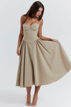 Rochie cu design minimalist bej cu bretele subțiri și fustă evazată medie pe model femeie