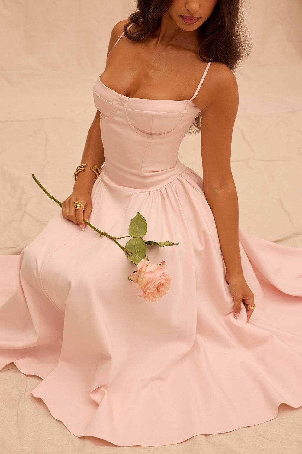 Rochie cu design minimalist roz pal cu bretele subtiri si fusta ampla, purtata de o femeie