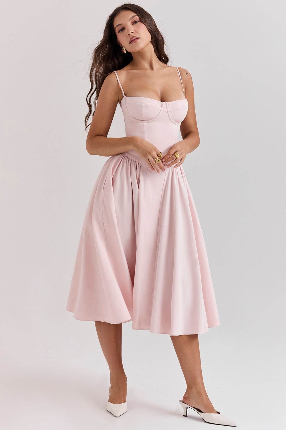 Rochie cu design minimalist roz pal, cu bretele subțiri și fustă evazată, purtată de femeie