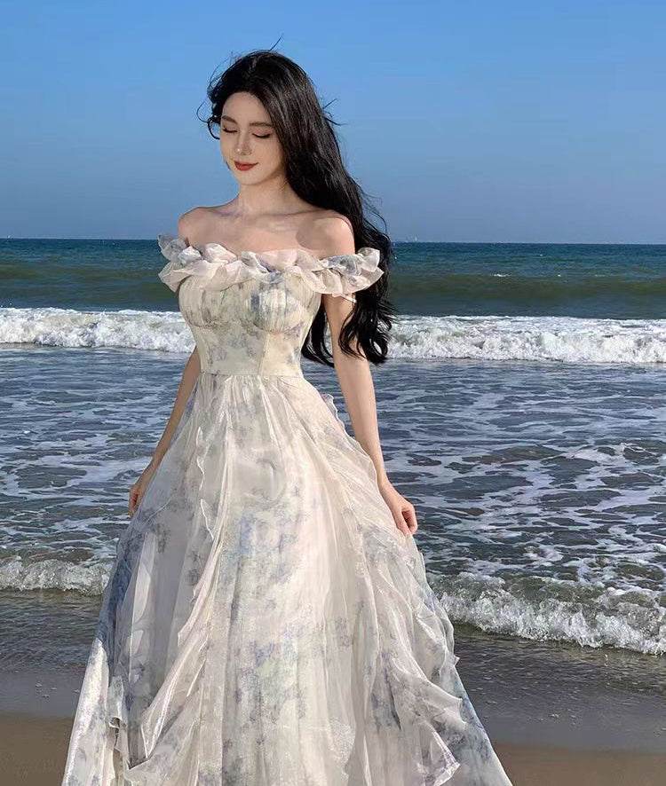 Rochie vaporoasă cu umeri goi si volane purtata pe plaja la malul marii