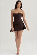 Rochie mini elegantă fară bretele în culoare maro purtată de model cu picioare goale