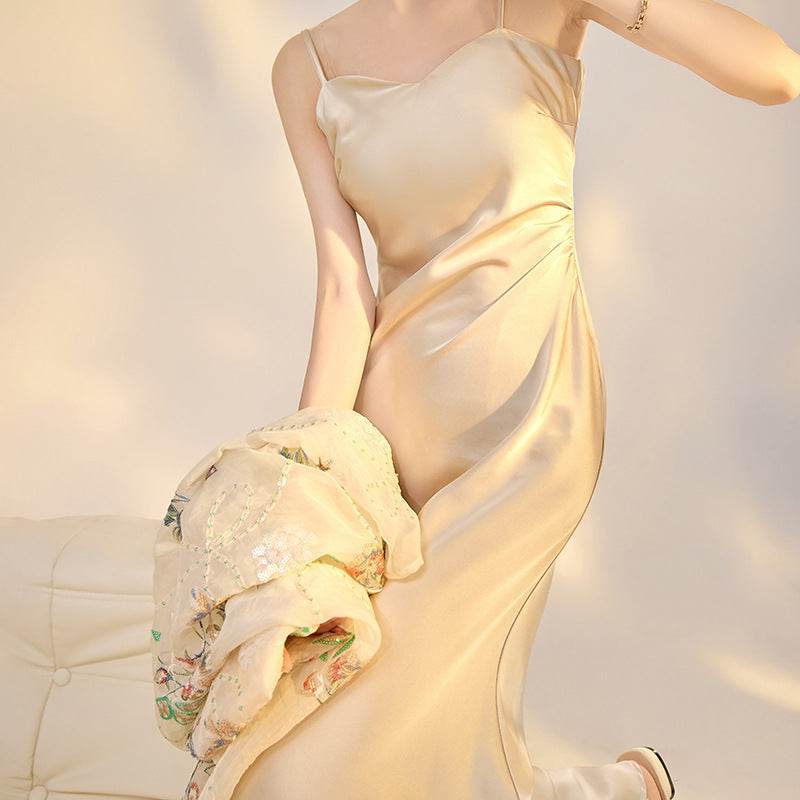 Rochie Satinată Slip Dress bej, elegantă, cu bretele subțiri, purtată de o femeie în lumină naturală