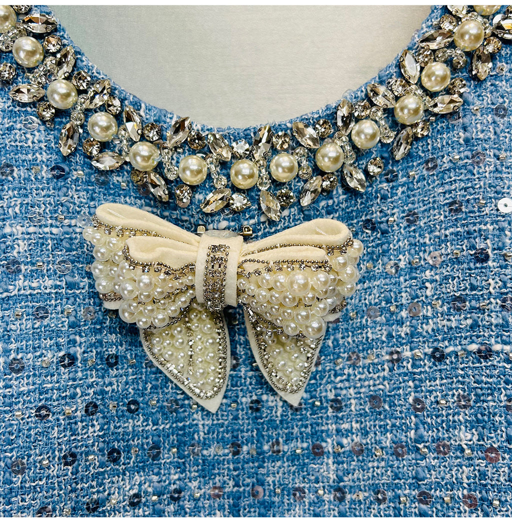 Close-up of the Sequined Bow Sleeveless Vest Dress featuring a decorative pearl and gem neckline