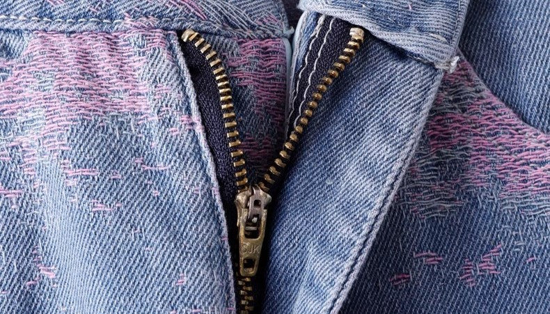 Close-up of Soft Pink Stitch Jeans featuring a detailed zipper design and textured fabric