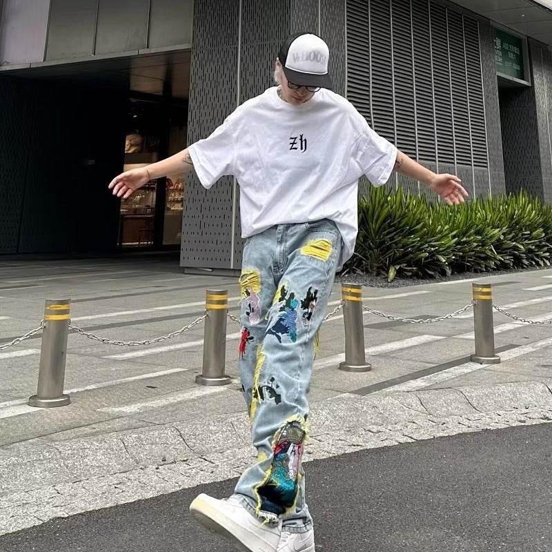 Model wearing Straight Fit Jeans with Artistic Design and casual oversized white t-shirt outdoors