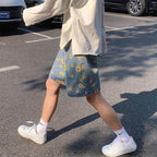 Casual outfit featuring summer streetwear floral shorts paired with a light shirt and white sneakers
