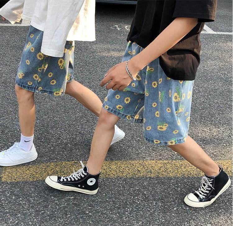 Two people wearing AM Vision RO summer streetwear floral shorts in blue with yellow flowers, styled casually
