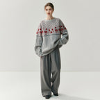 Stylish model wearing cozy Christmas knitwear with a festive design and wide gray trousers
