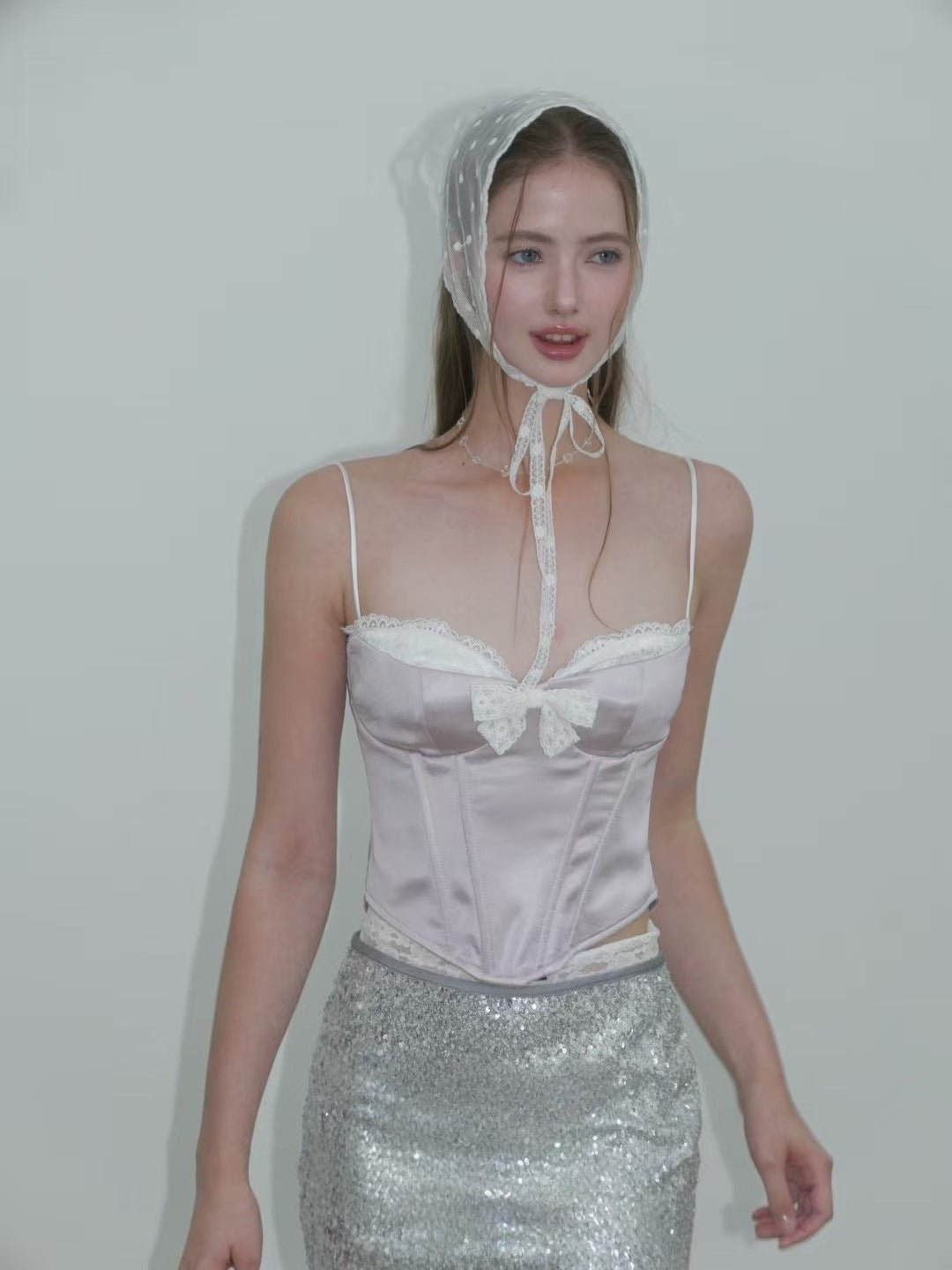 Model wearing the Sweet Desire Pink Bow Camisole with lace trim and stylish headscarf