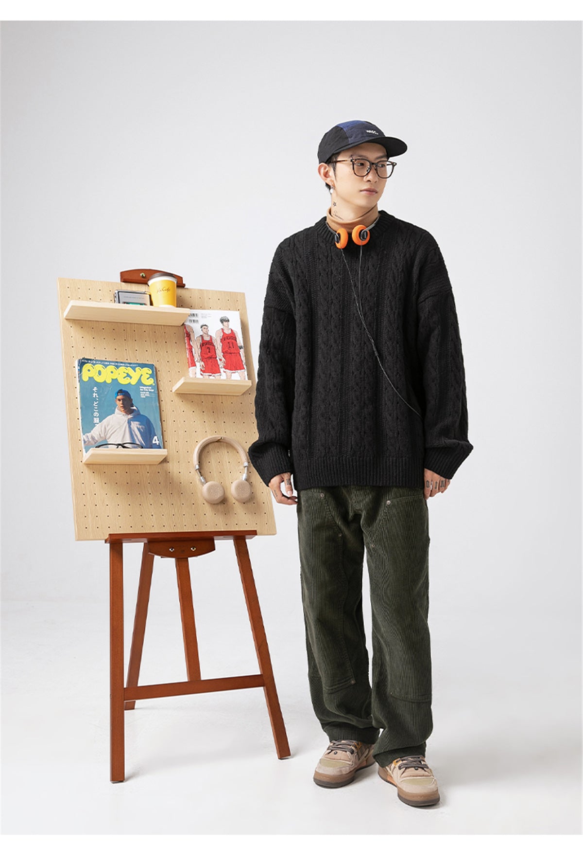 Casual model wearing a black Textured Cable Knit Sweater with stylish green pants and accessories