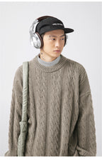 Model wearing a stylish Textured Cable Knit Sweater in brown with headphones and a cap