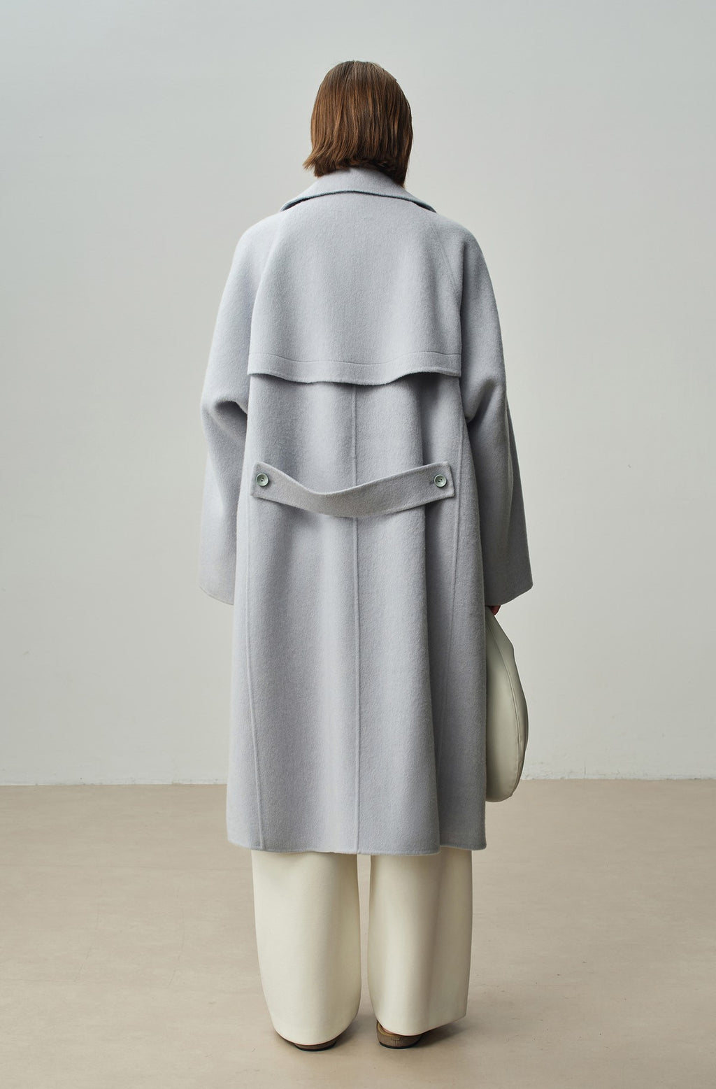 The Amaya Pastel Coat in light grey with a unique back design and stylish oversized fit