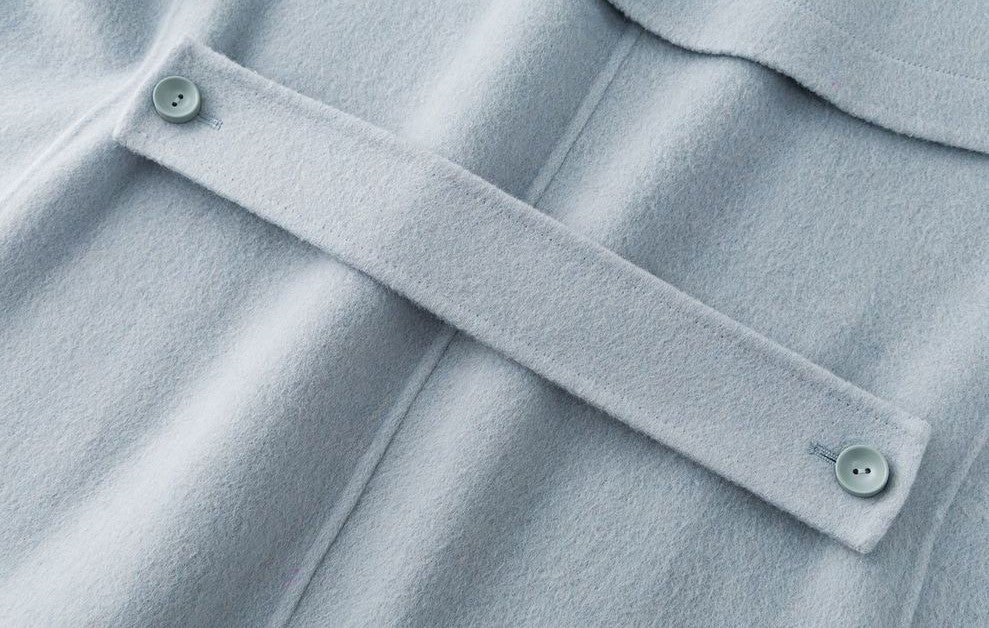 Close-up of The Amaya Pastel Coat with soft fabric and decorative buttons in light blue color