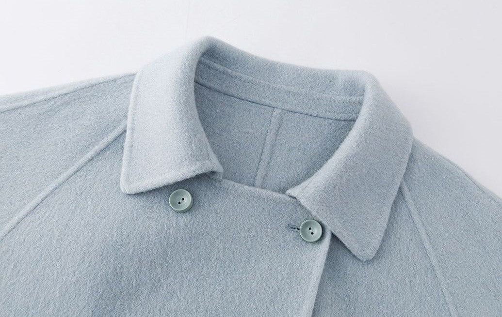The Amaya Pastel Coat featuring a soft blue fabric and stylish button closure